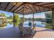 Enjoy lake views from this covered dock's seating area at 1523 Fishing Lake Dr, Odessa, FL 33556