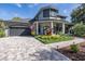 Two-story home with a gray exterior, paver driveway, and landscaped yard at 1523 Fishing Lake Dr, Odessa, FL 33556