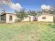 Backyard view of home with detached workshop and large grassy area at 18923 Rolling Oak Dr, Hudson, FL 34667