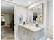 Well-lit bathroom with a vanity, mirror, and linen storage at 18923 Rolling Oak Dr, Hudson, FL 34667