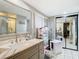 Clean bathroom with a large vanity, shower, and mirrored medicine cabinet at 18923 Rolling Oak Dr, Hudson, FL 34667