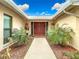 Inviting entryway with double doors and lush landscaping at 18923 Rolling Oak Dr, Hudson, FL 34667