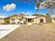 House exterior showcasing a stone fireplace and lush landscaping at 18923 Rolling Oak Dr, Hudson, FL 34667