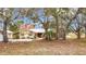 Ranch style home with mature trees, large yard, and driveway at 18923 Rolling Oak Dr, Hudson, FL 34667