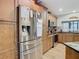 Stainless steel refrigerator in a kitchen with wood cabinets at 18923 Rolling Oak Dr, Hudson, FL 34667