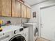 Bright laundry room with washer, dryer, and ample cabinetry at 18923 Rolling Oak Dr, Hudson, FL 34667