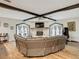 Spacious living room featuring a stone fireplace, vaulted ceiling with exposed beams, and large windows at 18923 Rolling Oak Dr, Hudson, FL 34667