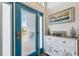 Bright entryway with teal door, decorative console table, and beach-themed art at 3215 Rose Arbor Dr, Hernando Beach, FL 34607