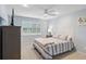Bright bedroom with striped bedding, a ceiling fan, and a large window at 3259 Hilary Cir # 1C, Palm Harbor, FL 34684