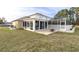 Back exterior view showing a house with a large patio and screened enclosure at 4332 Lamson Ave, Spring Hill, FL 34608