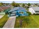 Aerial view of teal house with spacious yard and driveway at 4430 Floramar Ter, New Port Richey, FL 34652