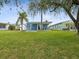 Landscaped backyard with a blue house at 4430 Floramar Ter, New Port Richey, FL 34652