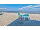 Two teal chairs and a table on the beach at 4430 Floramar Ter, New Port Richey, FL 34652