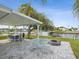 Covered patio with seating area, fire pit, and waterfront views at 4430 Floramar Ter, New Port Richey, FL 34652