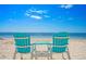 Two teal Adirondack chairs and small table overlooking the ocean at 4515 Marine Pkwy # 106, New Port Richey, FL 34652