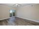 Bedroom with wood-look floors, a ceiling fan, and balcony access at 4516 Seagull Dr # 417, New Port Richey, FL 34652