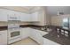 Modern kitchen featuring white cabinets, granite countertops, and stainless steel appliances at 4516 Seagull Dr # 417, New Port Richey, FL 34652
