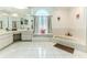Bright bathroom with a large soaking tub, window seat, tile floor, and a spacious vanity area at 5286 Hamlet Cir, Spring Hill, FL 34606
