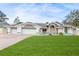 Home's front exterior showcases a manicured lawn, three-car garage, and decorative stonework at 5286 Hamlet Cir, Spring Hill, FL 34606