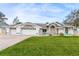A beautifully landscaped single-Gathering home featuring an attached three-car garage and stone accents at 5286 Hamlet Cir, Spring Hill, FL 34606