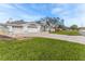 A single-Gathering home has a three-car garage and large front yard on a sunny day at 5286 Hamlet Cir, Spring Hill, FL 34606