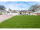 A single-Gathering home features an attached three-car garage, white paint, and a green lawn at 5286 Hamlet Cir, Spring Hill, FL 34606
