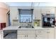 Practical kitchen area with a double sink, black appliances, and tiled backsplash at 5286 Hamlet Cir, Spring Hill, FL 34606