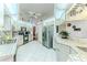 Well-lit kitchen featuring white cabinets, tile countertops, and modern stainless steel appliances at 5286 Hamlet Cir, Spring Hill, FL 34606