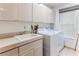 Functional laundry room with washer, dryer, sink, and ample cabinet space at 5286 Hamlet Cir, Spring Hill, FL 34606