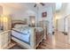 Sunlit main bedroom with a decorative ceiling fan, hardwood floors, and large windows at 5286 Hamlet Cir, Spring Hill, FL 34606