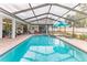 Large screened-in pool with a jacuzzi, ample lounging space and view of the backyard at 5286 Hamlet Cir, Spring Hill, FL 34606