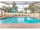 Sparkling screened-in pool with umbrella and lounge chairs, perfect for relaxation at 5286 Hamlet Cir, Spring Hill, FL 34606