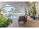Inviting screened-in pool area with comfortable seating and lush tropical landscaping at 5286 Hamlet Cir, Spring Hill, FL 34606