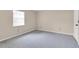 Simple carpeted bedroom with a window and ample wall space at 6033 Wilds Dr # B07, New Port Richey, FL 34653