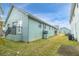 Back exterior view showing a light teal building, grass and patio at 6033 Wilds Dr # B07, New Port Richey, FL 34653