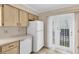 Efficient kitchen features light wood cabinets, white appliances, and a door to outside at 6033 Wilds Dr # B07, New Port Richey, FL 34653