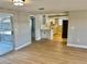 Bright living room with light wood laminate flooring and view of kitchen at 7207 Nova Scotia Dr, Port Richey, FL 34668