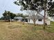View of the house from the backyard, showing a large lawn at 8111 Merrimac Dr, Port Richey, FL 34668
