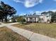 Landscaped yard with a single-story house and palm trees at 8111 Merrimac Dr, Port Richey, FL 34668