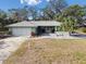 Ranch style home with a two-car garage, palm trees, and a well manicured lawn at 8446 Braganza St, Spring Hill, FL 34608