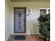 Gray front door with an ornate metal security screen and a terracotta tile entryway at 8446 Braganza St, Spring Hill, FL 34608