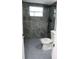 Updated bathroom with grey tile and penny round floors at 8703 Robilina Rd, Port Richey, FL 34668