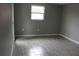 Gray walls, gray tile floor, and a window in bedroom at 8703 Robilina Rd, Port Richey, FL 34668