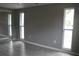 Gray walls, gray tile floors, and two windows at 8703 Robilina Rd, Port Richey, FL 34668