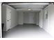 Spacious garage interior with ample storage and overhead lighting at 8703 Robilina Rd, Port Richey, FL 34668