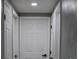 Clean hallway with white doors and grey walls at 8703 Robilina Rd, Port Richey, FL 34668