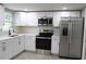 Updated kitchen featuring white cabinets and stainless steel appliances at 8703 Robilina Rd, Port Richey, FL 34668