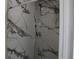 Modern shower with marble wall and penny round floor tile at 8703 Robilina Rd, Port Richey, FL 34668