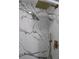 Modern shower with gold fixtures and marble-style walls at 8703 Robilina Rd, Port Richey, FL 34668
