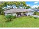 Brick house with lush lawn, palm trees, and a covered porch at 8809 Shoemaker Ln, Hudson, FL 34667